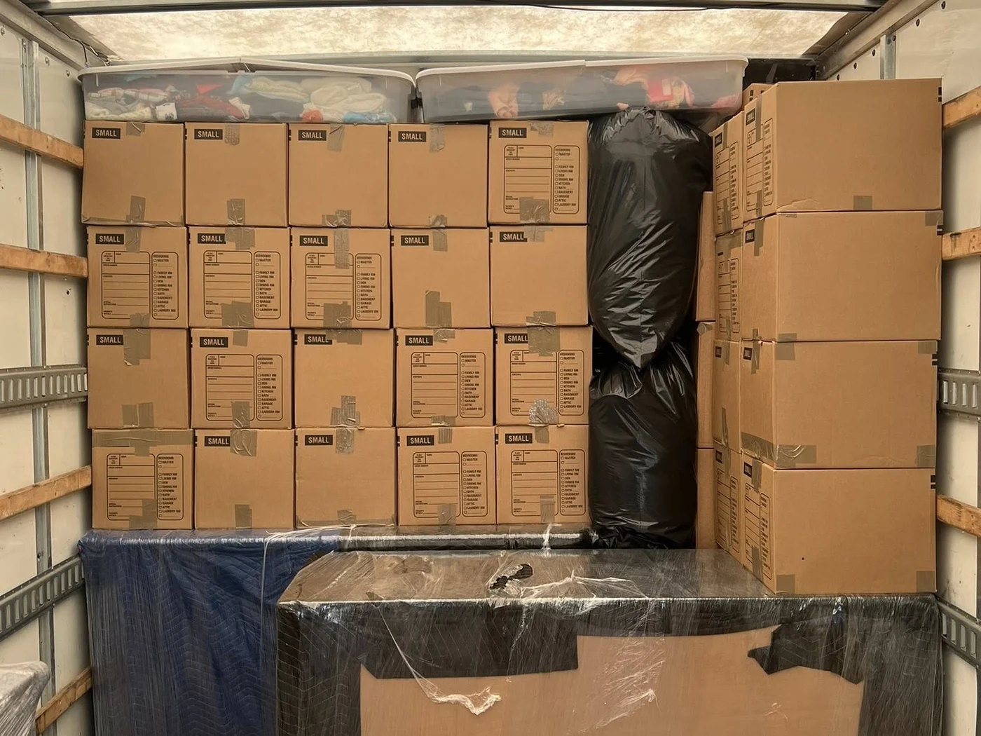 Stacked moving boxes arranged inside a moving truck