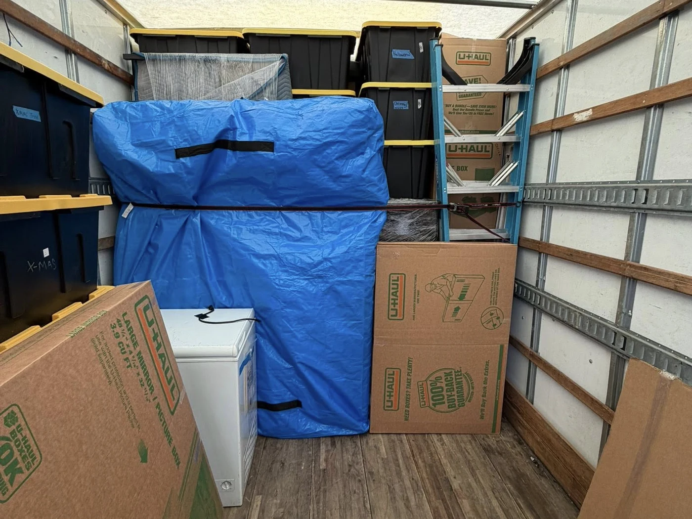 Protected furniture and moving boxes loaded inside a moving truck