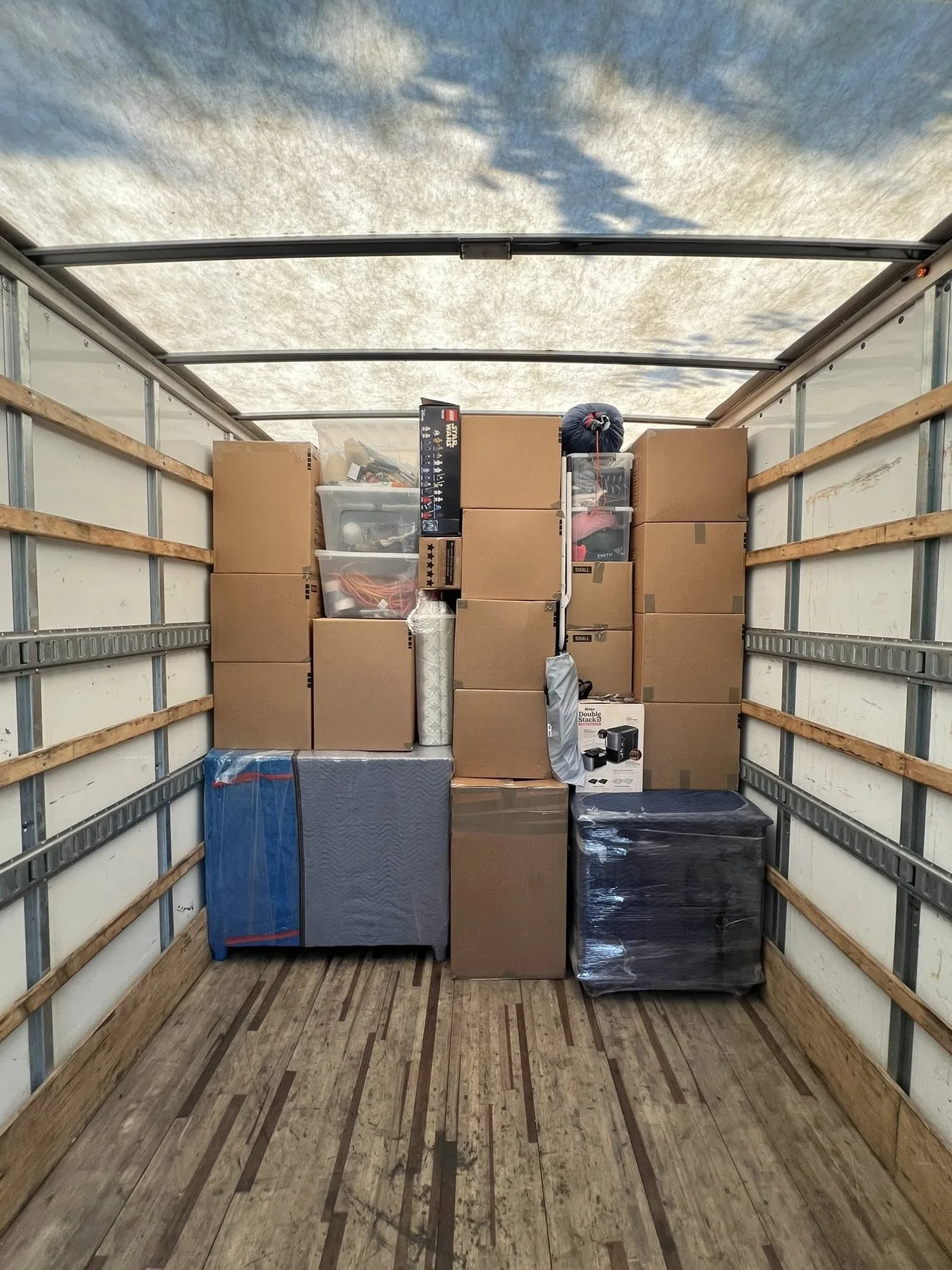 Organized boxes and protected household goods loaded into a moving truck