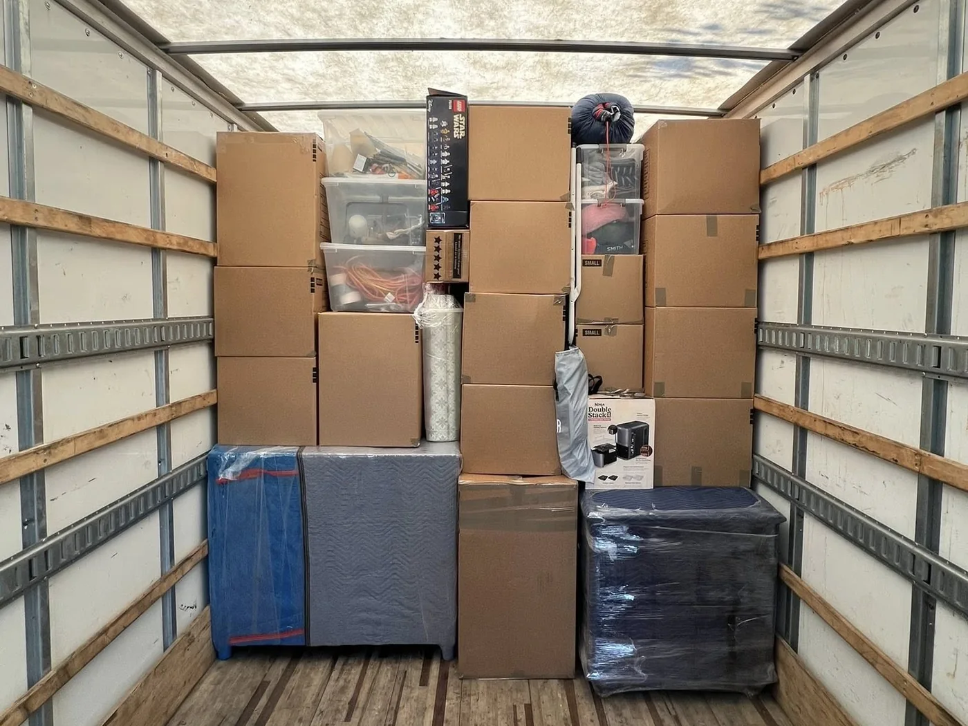 Household boxes and protected items organized inside a moving truck